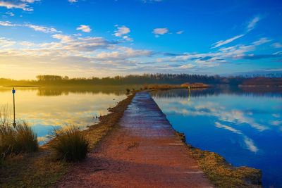 Scenic view of lake against sky at sunset