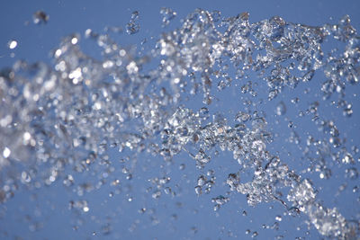 Close-up of water splashing against blue background