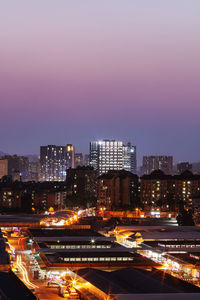 High angle view of illuminated city at sunset
