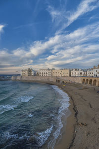 Scenic view of beach against cloudy sky