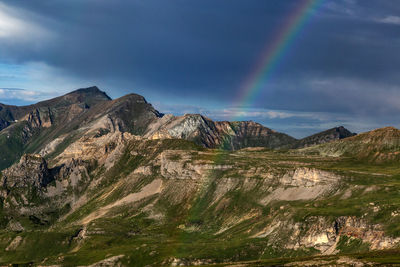 Scenic view of rainbow over mountains against sky