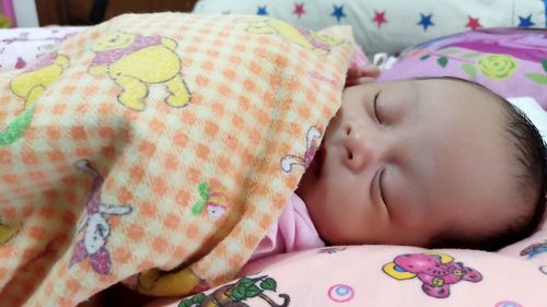 Portrait of cute baby sleeping on bed