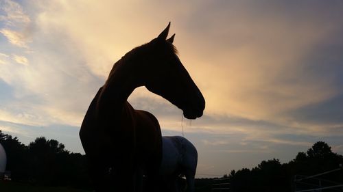 Silhouette sculpture against sky during sunset