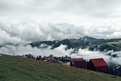 Scenic view of cloud covered  mountain village against sky