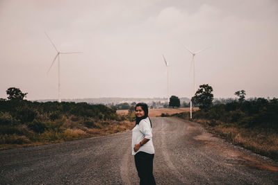 Portrait of man standing on road against sky