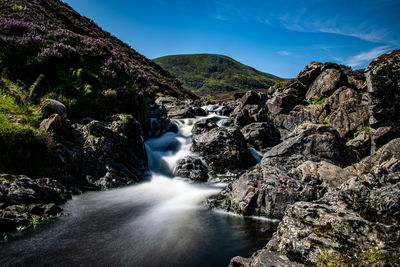 Scenic view of waterfall against sky