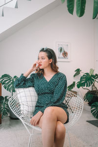 Young woman sitting on chair at home