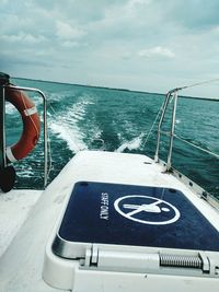 Close-up of boat in sea against cloudy sky