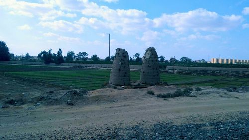 Ruins of building on field against cloudy sky