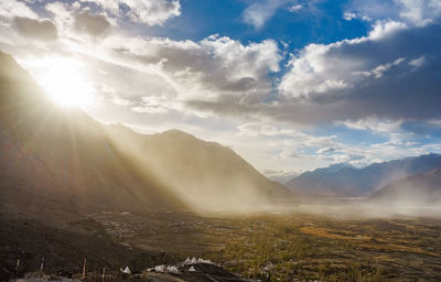 Scenic view of mountains against bright sun