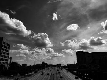 Road amidst buildings in city against sky