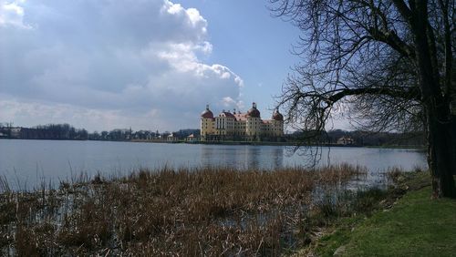 Calm lake with buildings in background