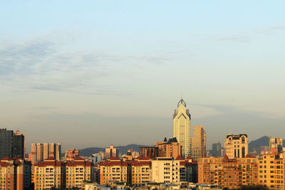 Buildings in city against sky during sunset