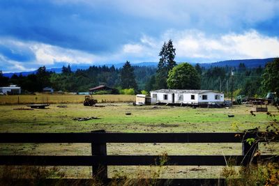 Houses of field against cloudy sky