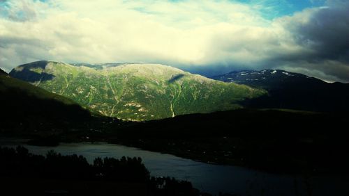 Scenic view of mountains against cloudy sky