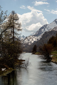 Scenic view of lake by snowcapped mountains against sky