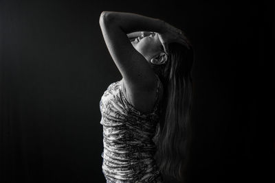 Low section of woman looking away against black background