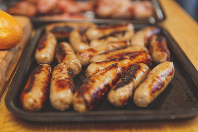 Close-up of grilled sausages in tray on table