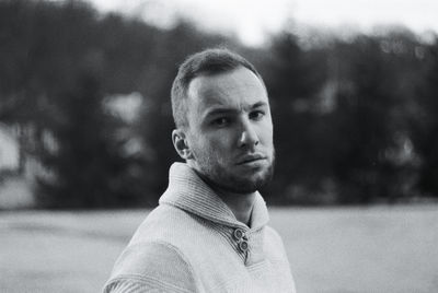 Portrait of young man standing in field