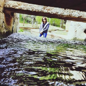 Portrait of young woman standing in water