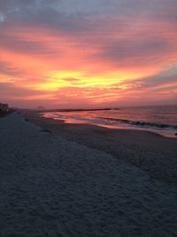 Scenic view of beach against dramatic sky