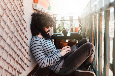 Side view of man using laptop