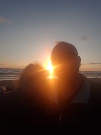 Close-up of silhouette person on beach against clear sky during sunset