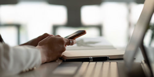 Midsection of man using mobile phone
