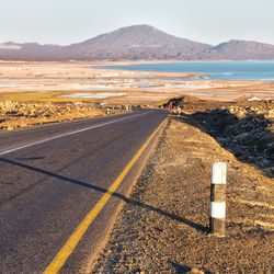 Scenic view of road by sea against sky