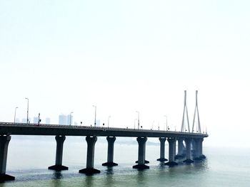 Bridge over sea against clear sky