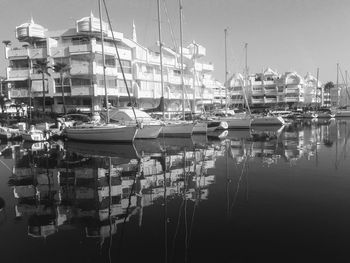 Sailboats moored in harbor