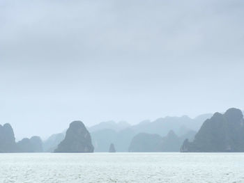 Scenic view of sea and mountains against clear sky