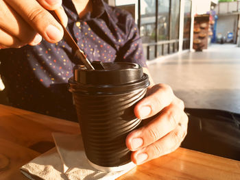 Midsection of man holding coffee