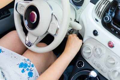 Midsection of woman holding steering wheel