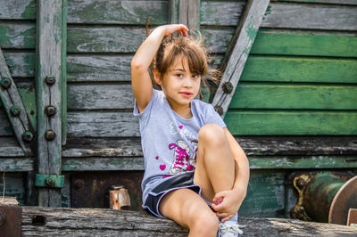 Little blonde girl posing in front of old train wagon