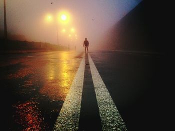 Full length of people walking on illuminated walkway