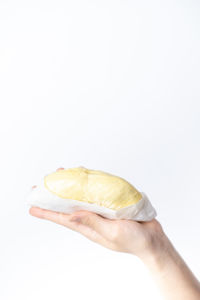 Close-up of hand holding bread against white background