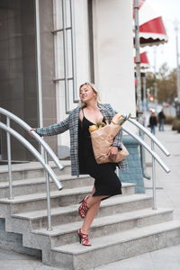 Full length of young woman standing on stairs