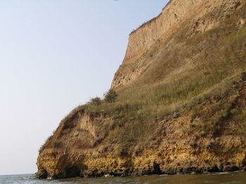 View of rock in sea against clear sky