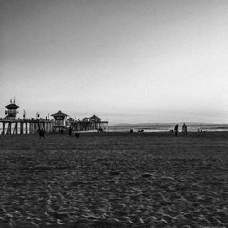 People on beach against clear sky