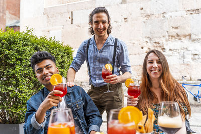 Portrait of friends holding drinks