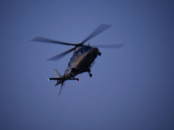 Low angle view of helicopter flying against clear sky