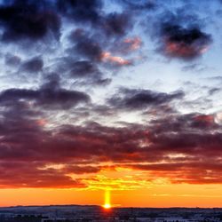 Scenic view of sea against cloudy sky during sunset