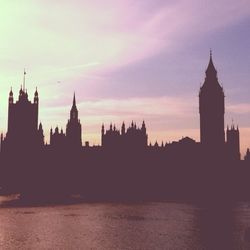 Silhouette buildings in city against sky at sunset