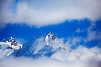 Low angle view of snowcapped mountains against sky