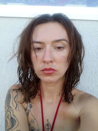 Portrait of beautiful woman against wall