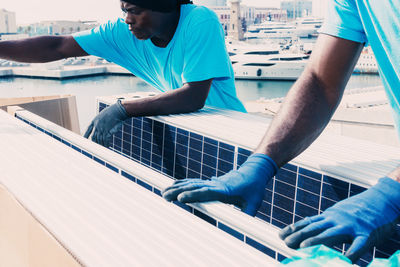 Low angle view of man working against blue sky