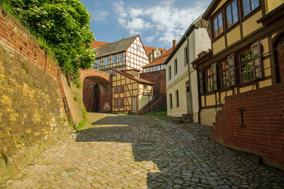 Footpath amidst buildings against sky