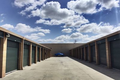 Footpath amidst buildings against sky