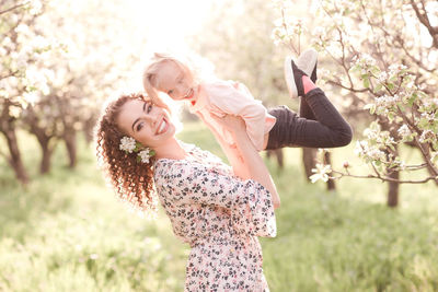 Happy mother playing with daughter in park